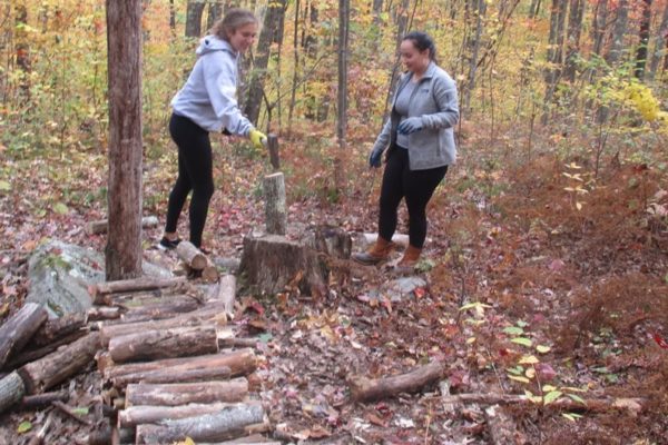 Holy Cross Students Eliza and Charlotte Splitting Wood at the Hermitage
